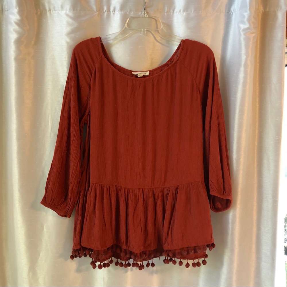 deep orange peplum top with poms